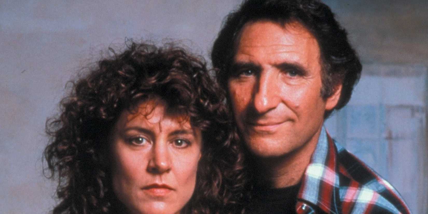 Judd Hirsch smiles slightly and Christine Lahti look at the camera in 'Running on Empty'.
