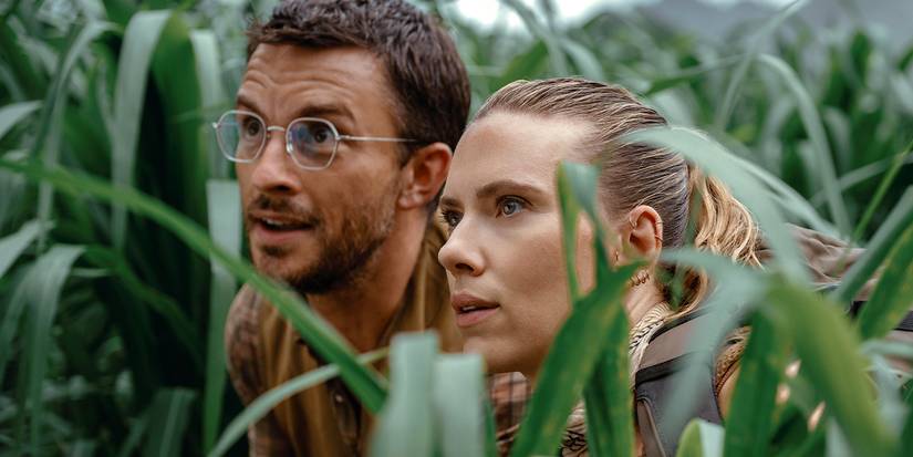 Dr. Henry Loomis (Jonathan Bailey) and Zora Bennett (Scarlett Johansson) stare up at a dinosaur in Jurassic World Rebirth.