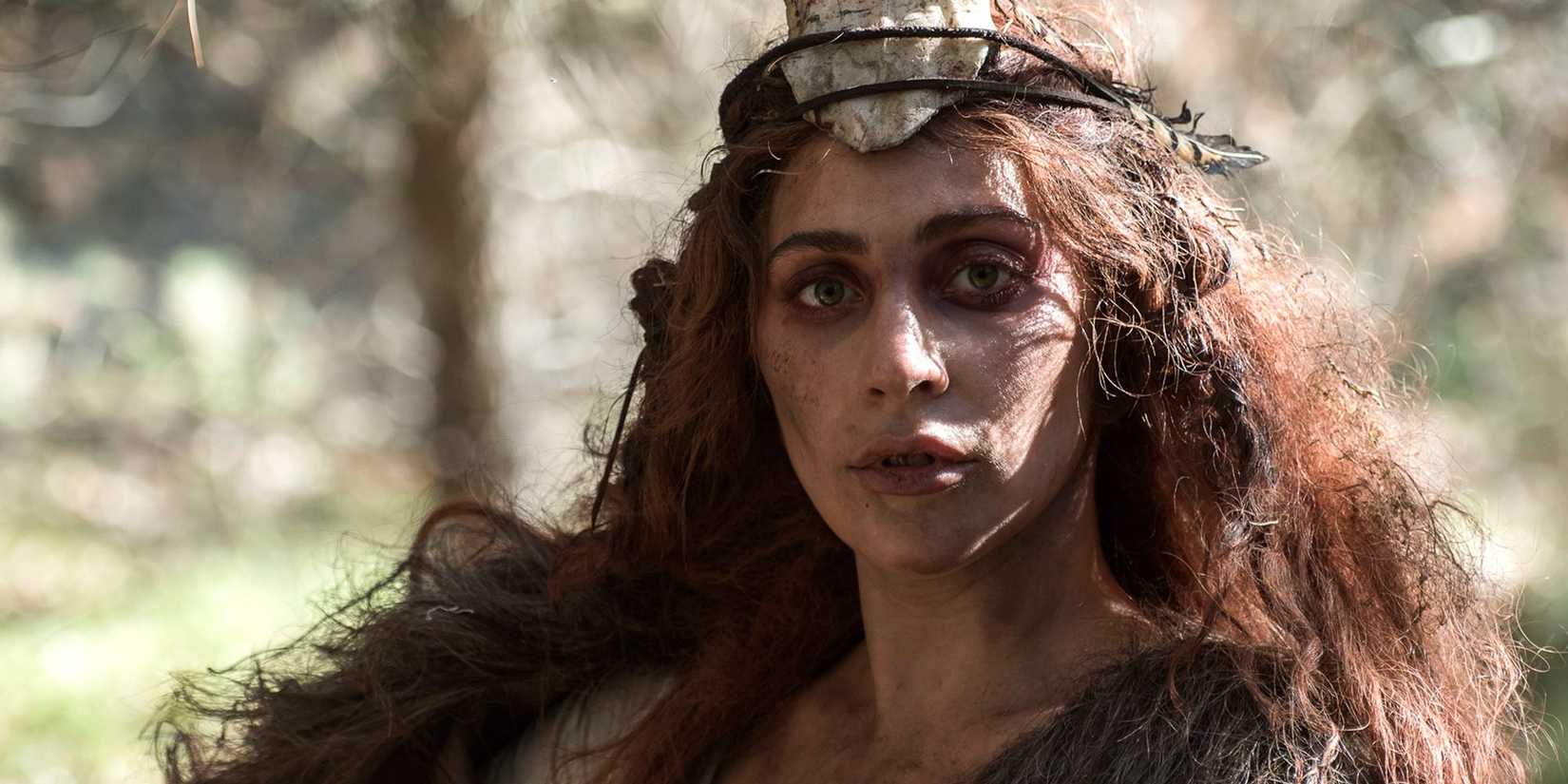 Lady Gaga with messy brownish red hair and dirt all over her face as Scáthach in American Horror Story: Roanoke