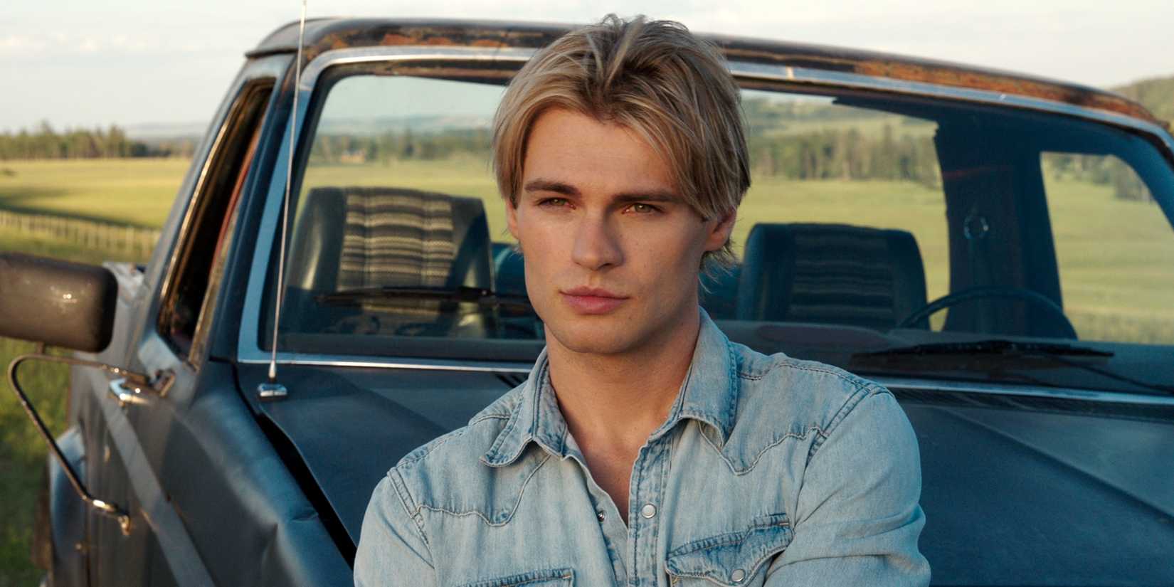Noah LaLonde as Cole Walter standing outside and leaning against his car in My Life with the Walter Boys