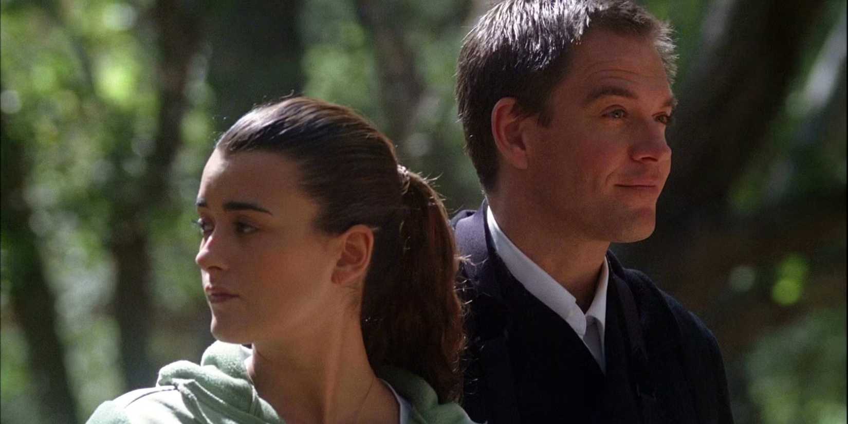 Tony and Ziva on a mission looking in separate directions outdoors in NCIS.