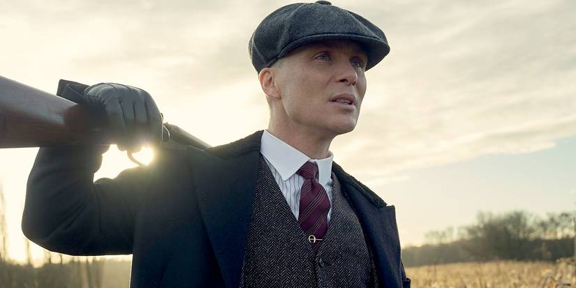 Cillian Murphy as Tommy Shelby with a gun over his shoulder in Peaky Blinders