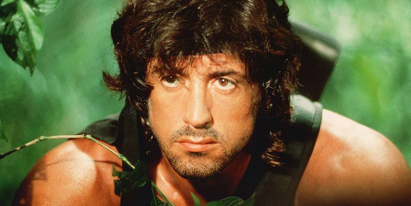 Sylvester Stallone's Rambo crouching in the jungle in First Blood Part 2