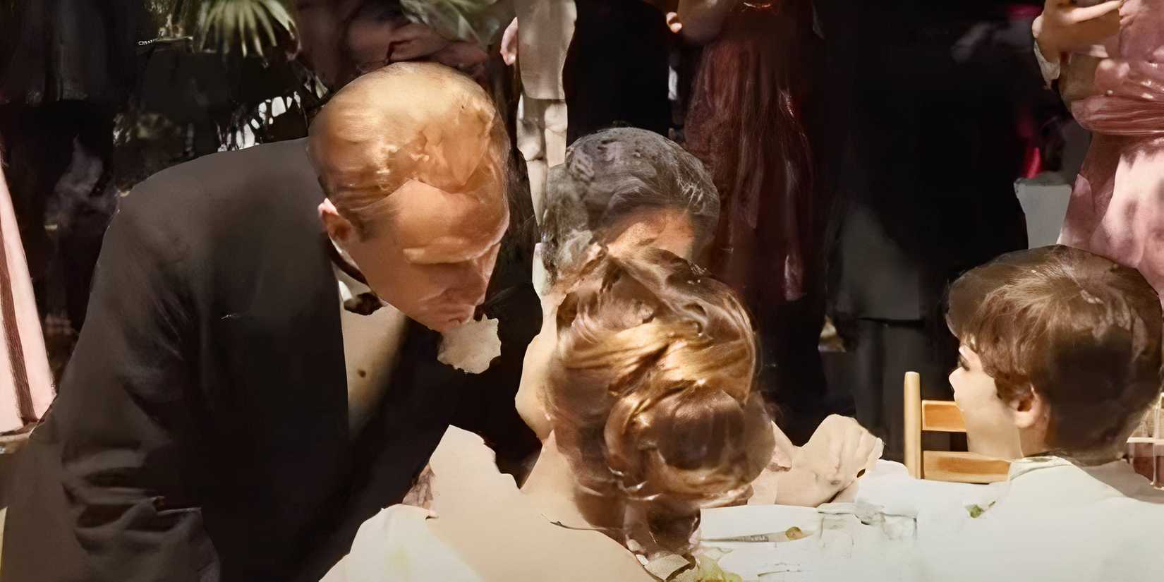 Robert Duvall as Tom Hagen leaning over looking at his wife sitting at a table in The Godfather (1972)