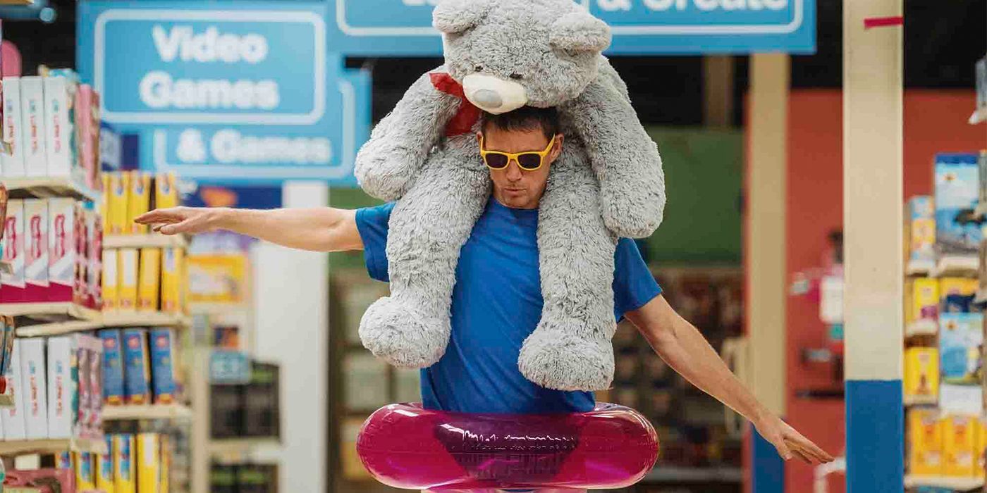 Channing Tatum walks through a vacant Toys R Us with a giant bear on his shoulders in Roofman.
