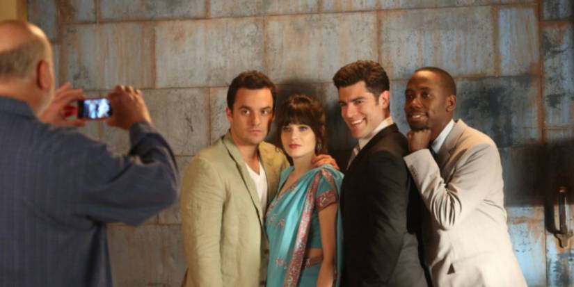 Jake Johnson, Zooey Deschanel, Max Greenfield, Lamorne Morris as Nick, Jess, Schmidt, and Winston posing and smiling for a photograph in 'New Girl.'