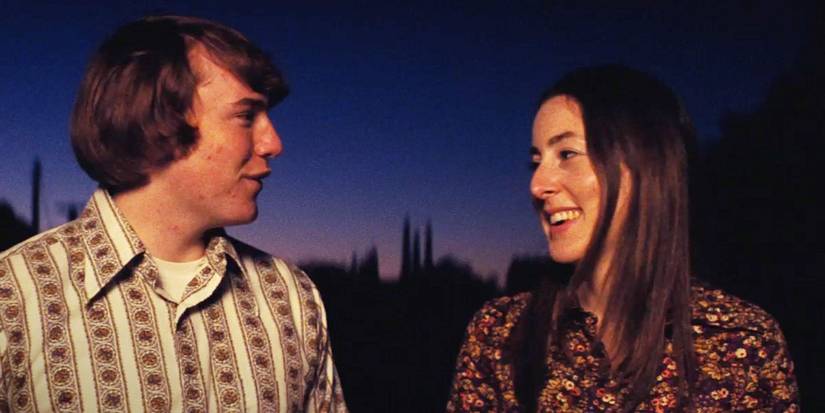 Cooper Hoffman and Alana Haim as Gary and Alaina smiling at each other walking at sunset in 'Licorice Pizza'