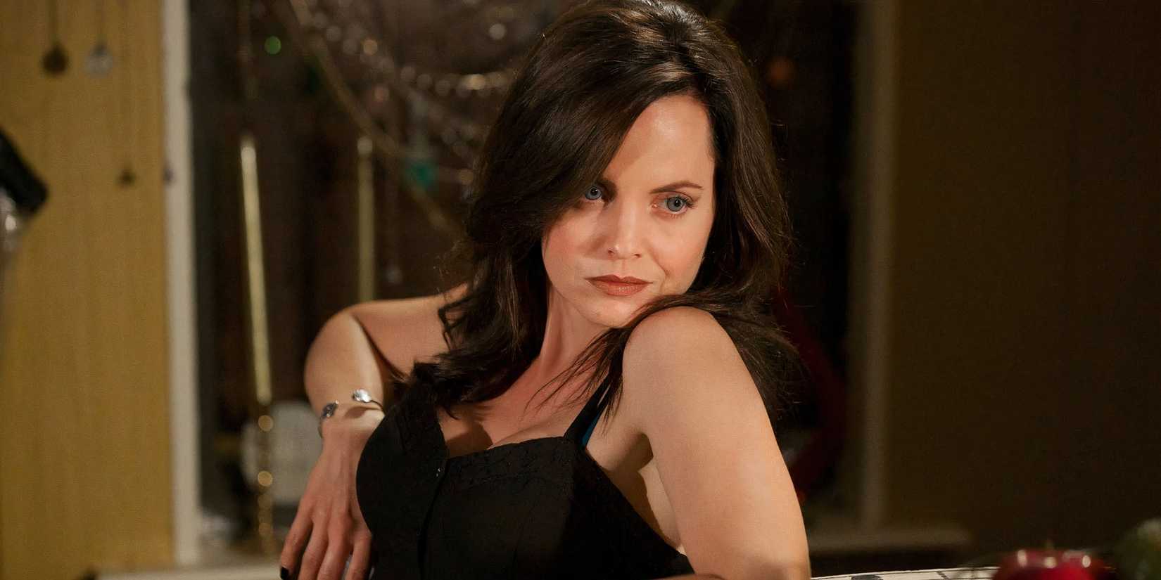 Uz dienvidiem no Hell's Mena Suvari, kas nedaudz skatās uz ekrāna, kamēr viņas zods balstās uz pleca. 