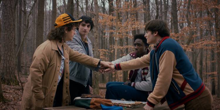 Gaten Matarazzo as Dustin, Finn Wolfhard as Mike, Caleb McLaughlin as Lucas, and Noah Schnapp as Will are hands in on 'Stranger Things' Season 5.