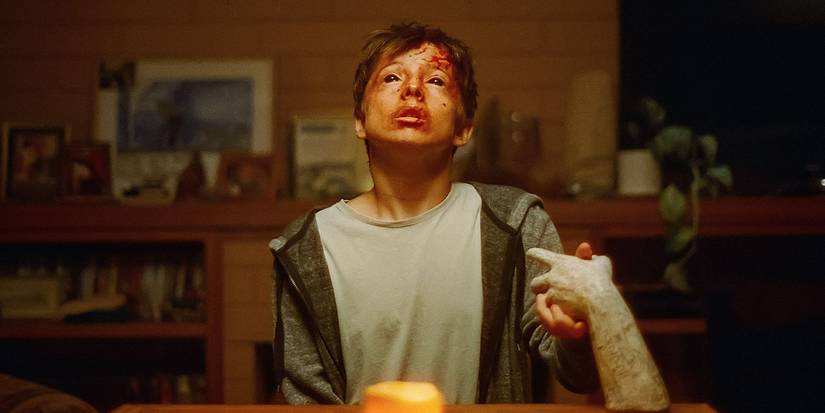 A teen boy holding an embalmed hand and becoming possessed in Talk To Me