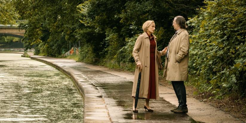 Diana Taverner and Jackson Lamb standing next to a river and a treeline and talking in Slow Horses.