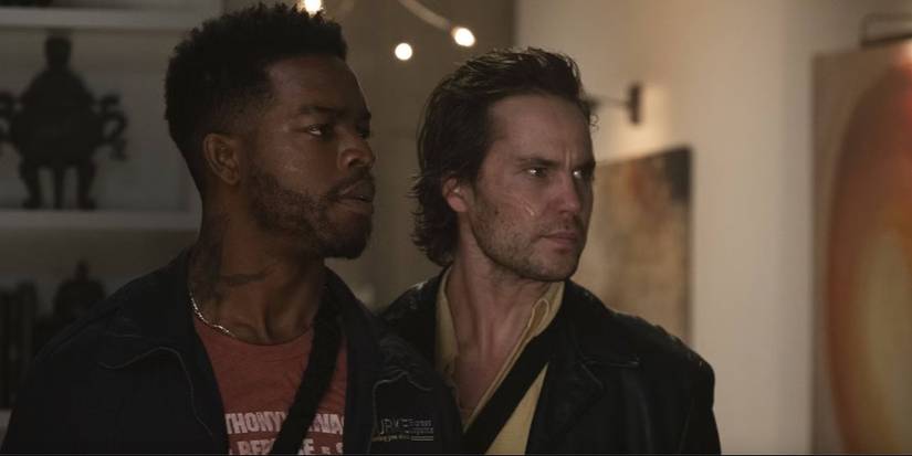 Taylor Kitsch and Stephan James looking to their left at someone off-screen in 21 Bridges