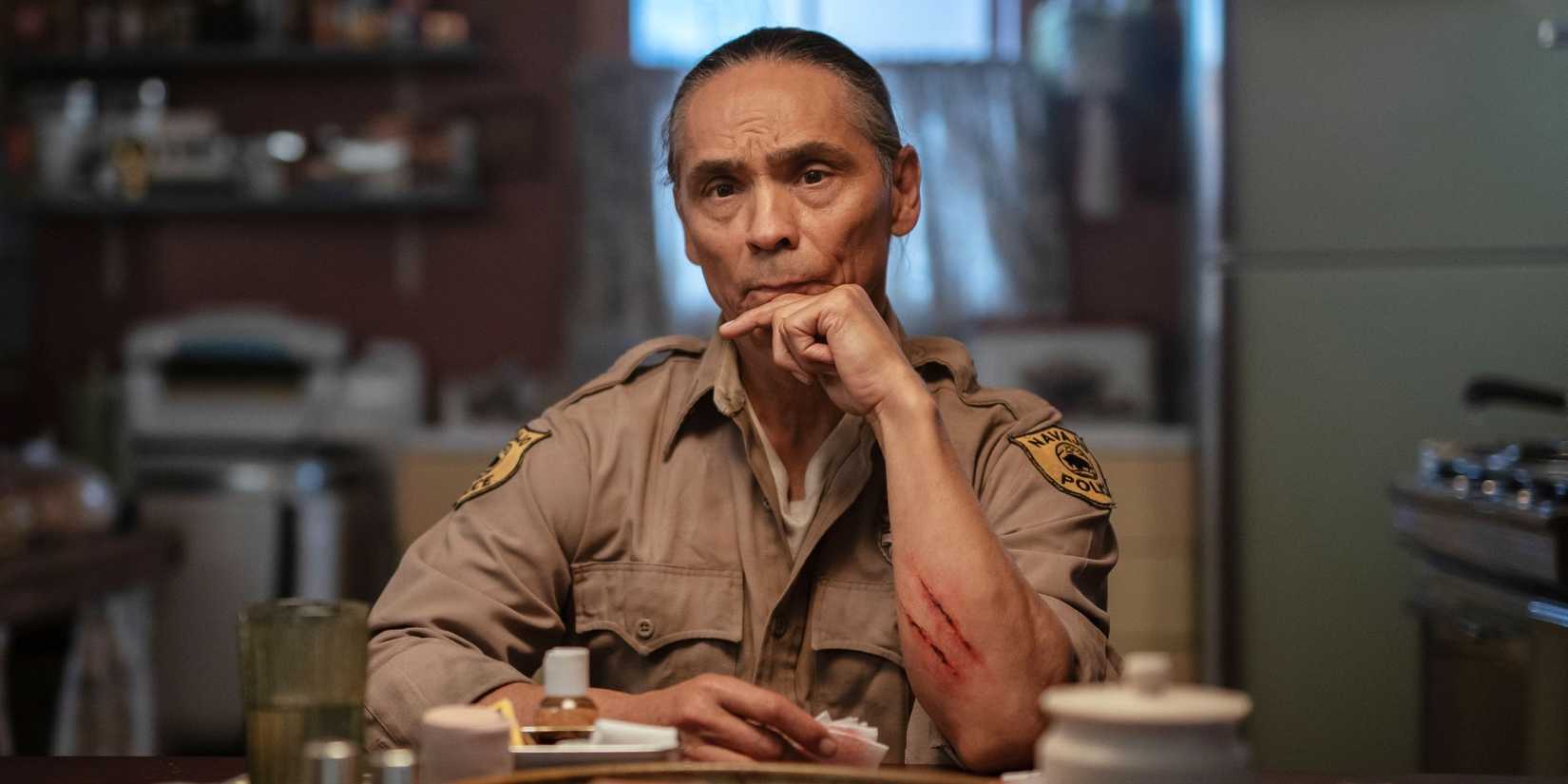 Zahn McClarnon sits thinking at a kitchen table in Dark Winds.