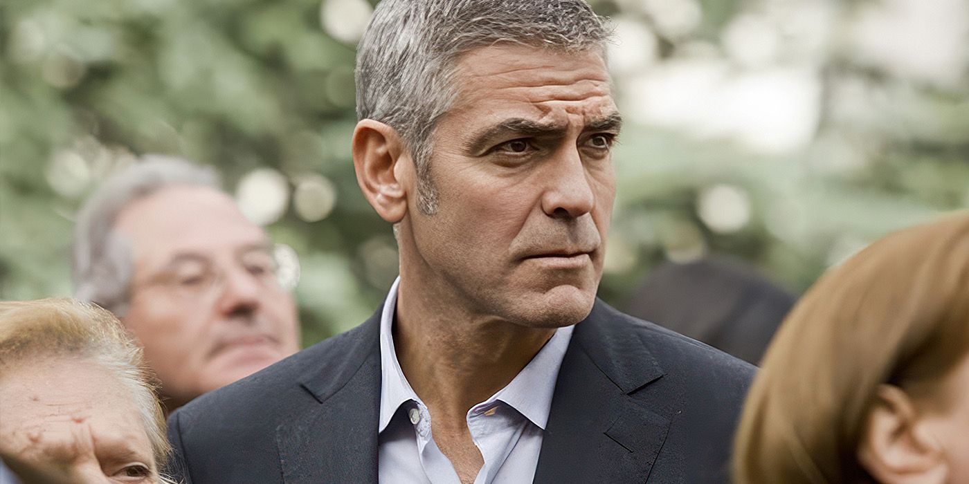 George Clooney looks serious in a crowd in The American