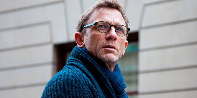 Daniel Craig wearing a sweater and glasses looks up outside in Girl With the Dragon Tattoo