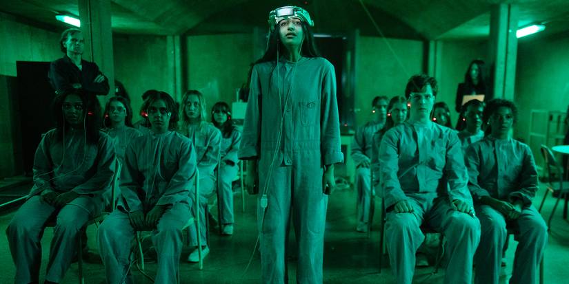 A child with a headset on stands among others in the evil lab of the Stephen King series The Institute.