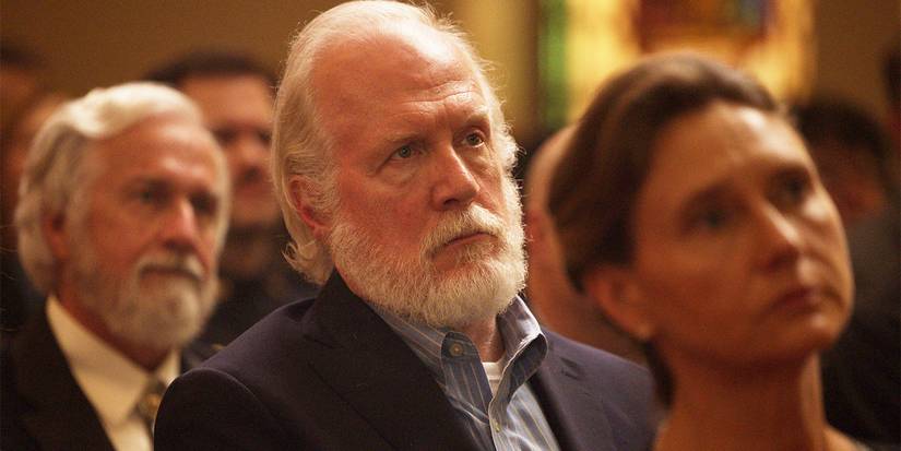 Tracy Letts as Frank Martin dressed in a suit while sitting at church in The Lowdown