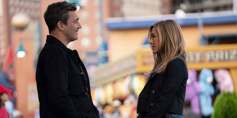 Paul and Alex looking at one another while at a fair in The Morning Show.