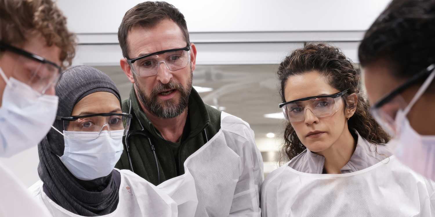 Noah Wyle among other doctors wearing goggles and scrubs in The Pitt
