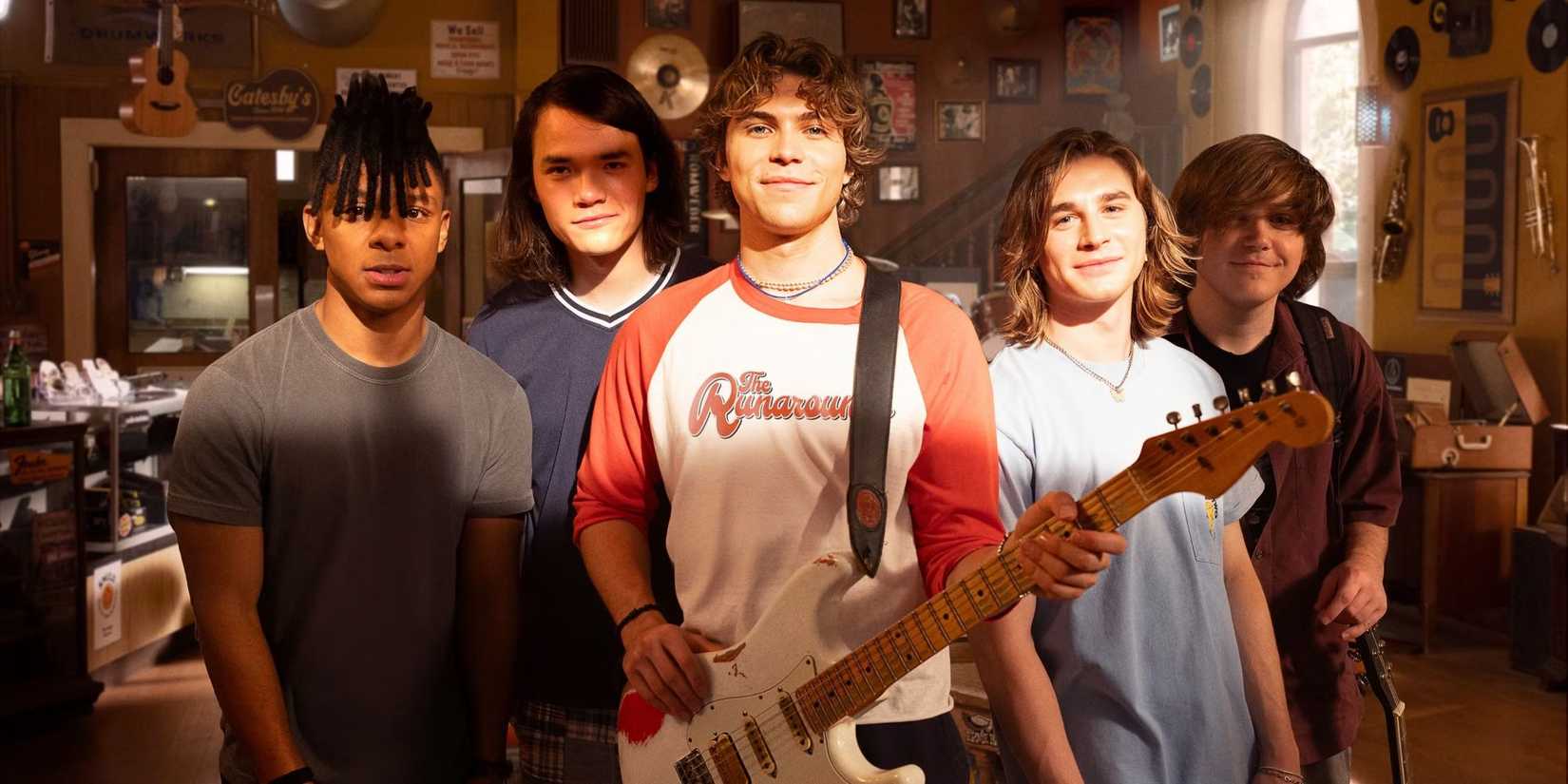 The cast of The Runarounds hold musical instruments and look at the camera.