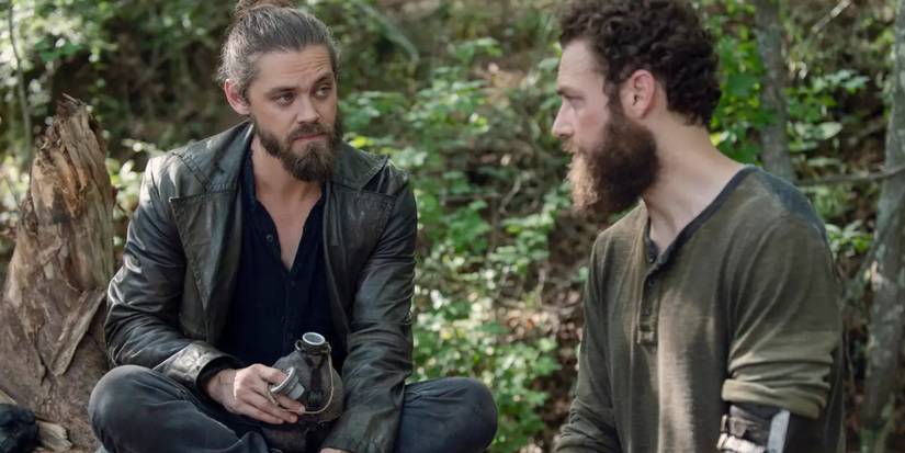 Tom Payne as Paul "Jesus" Rovia and Ross Marquand as Aaron talking in the woods on The Walking Dead.