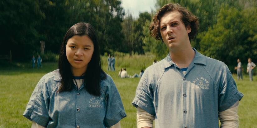 Two teens wearing "Tall Pines Academy" embroidered jumpsuits stand outside in Wayward.