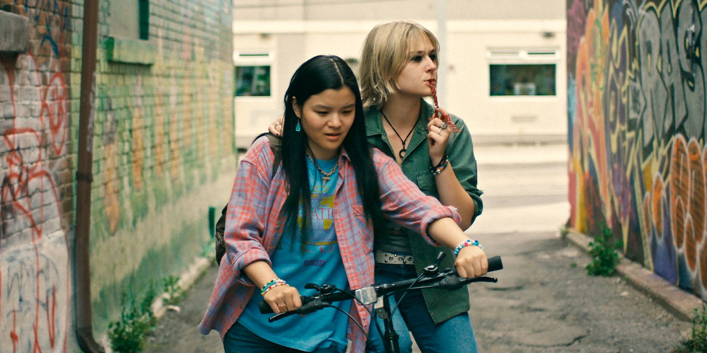 Two teens travel down an alley and one is on a bike in Wayward.