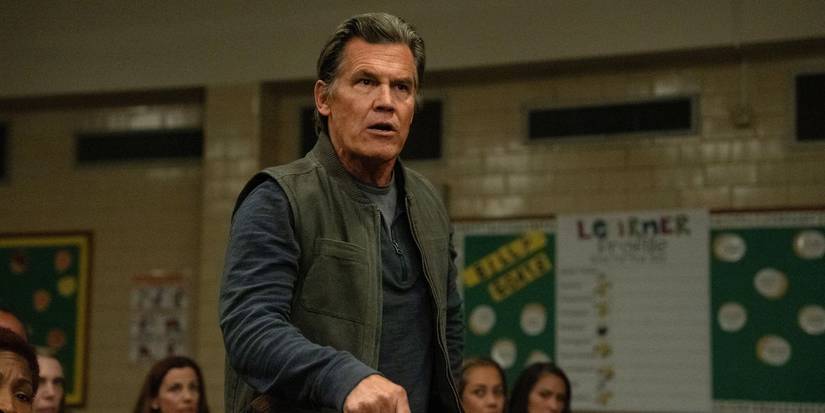 Josh Brolin as Archer standing up in a school auditorium in Weapons.