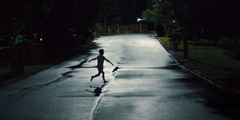 A young child, running down an empty street at night, in Weapons.