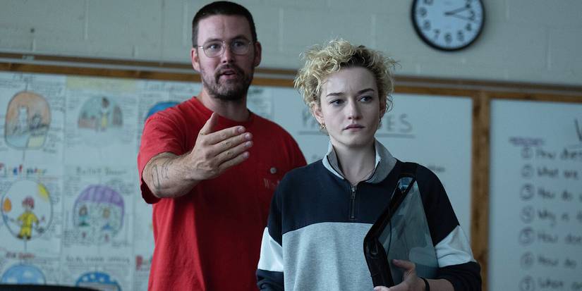 Zach Cregger standing in a classroom next to Julia Garner on the set of Weapons.