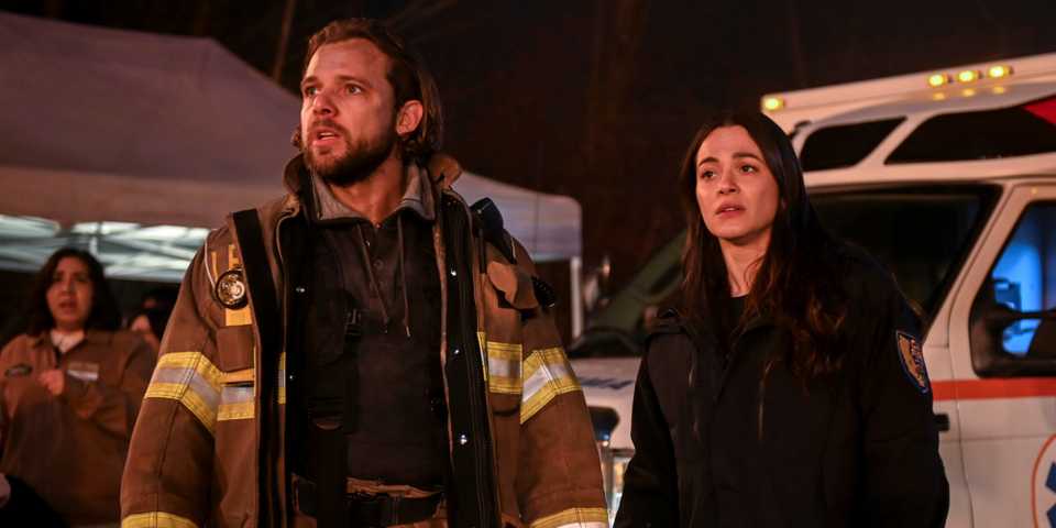 Max Thieriot as Bode with Stephanie Arcila as Gabriela standing outside a fire in Fire Country Season 3