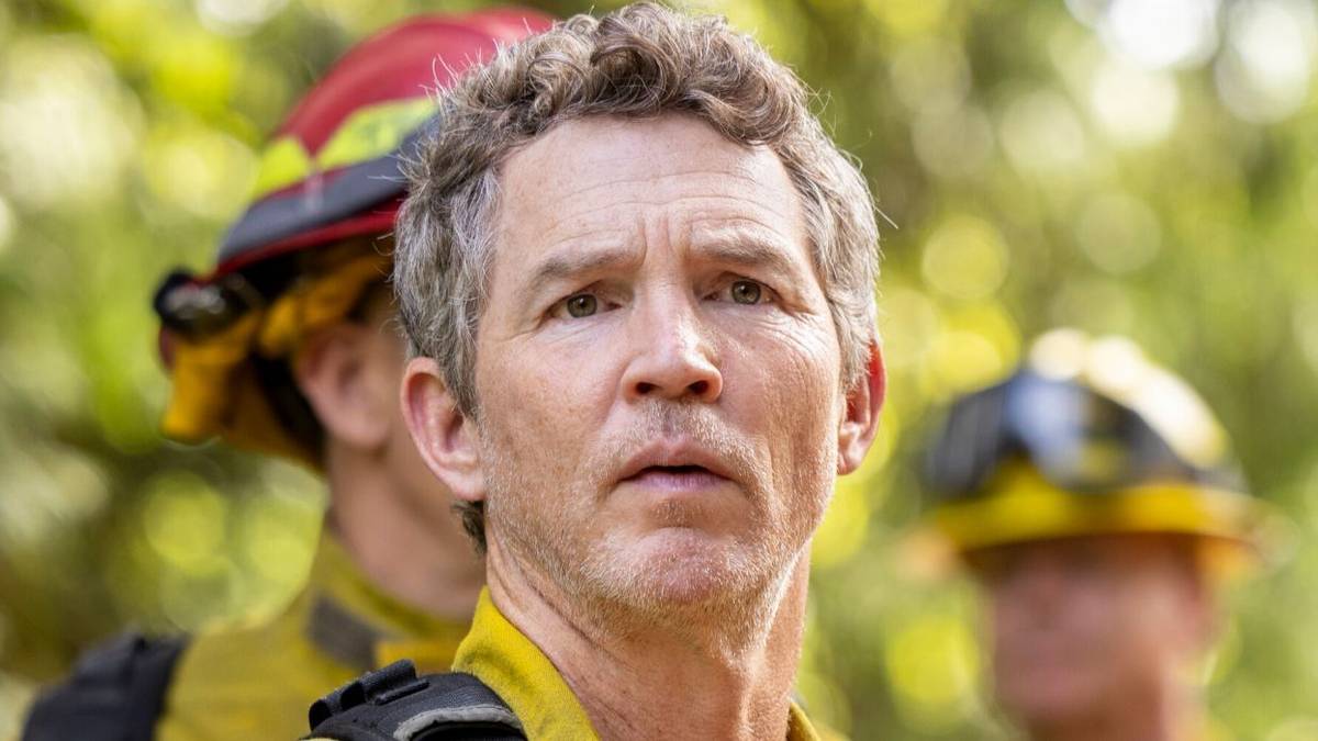 Shawn Hatosy looking toward camera, worried, with two other firefighters behind him