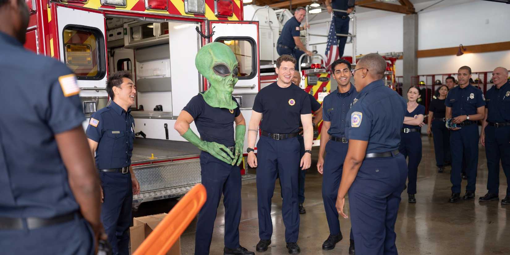 Chimney, Eddie (wearing a green alien head), Buck, Ravi, and Hen standing together and laughing at the firehouse in 9-1-1 Season 9