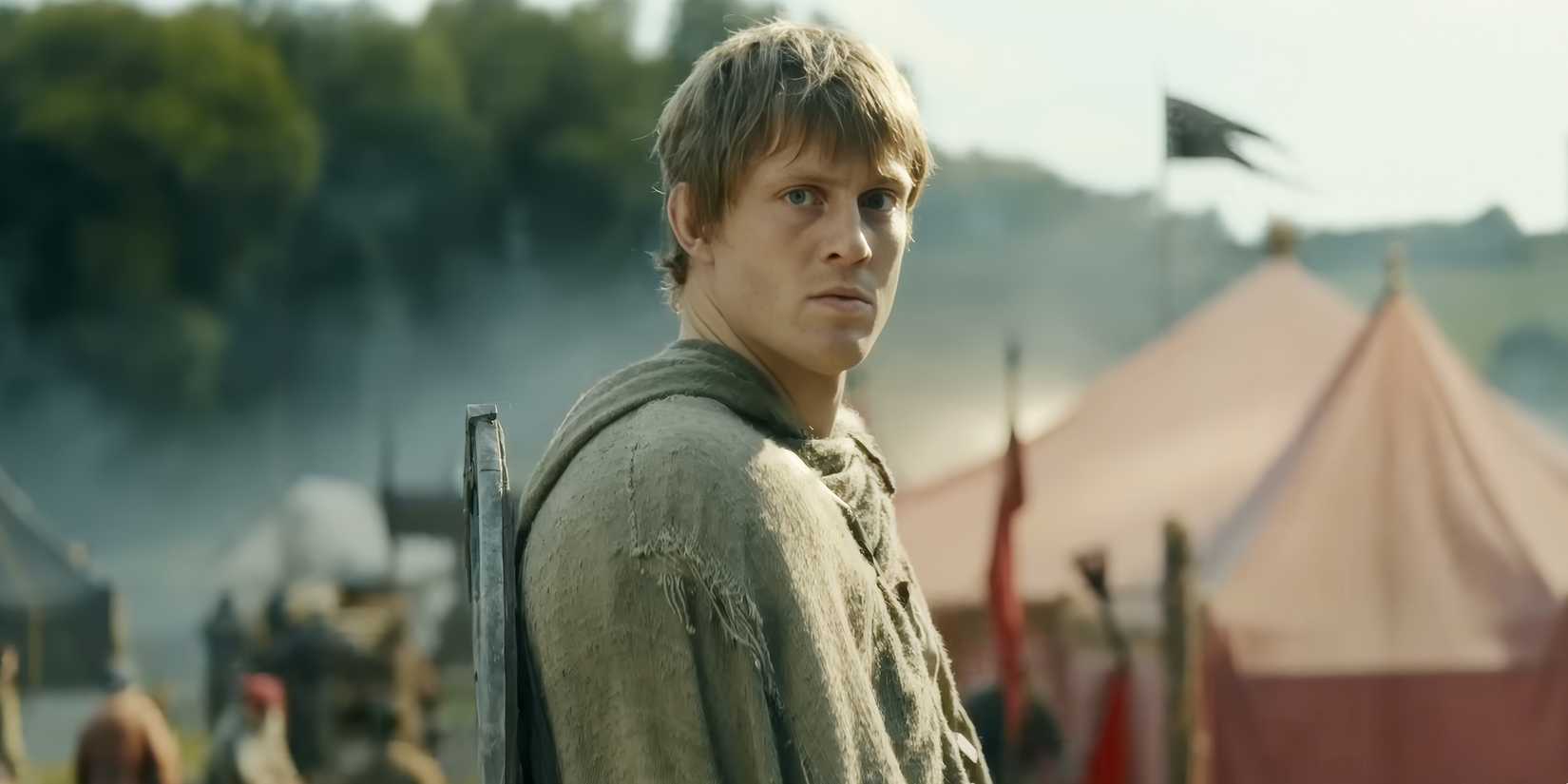 "Dunk the Tall" looking back with a shield over his shoulder in the middle of busy camp grounds.