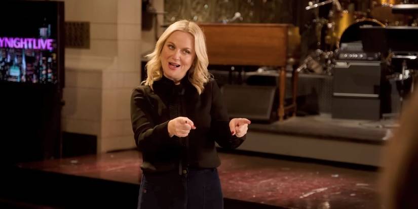 Amy Poehler smiling and pointing in a promo for SNL Season 51 Episode 2.