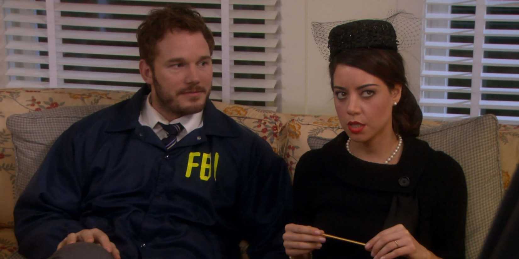 Chris Pratt as Andy sits next to Aubrey Plaza as April dressed up for Halloween in Parks and Recreation.