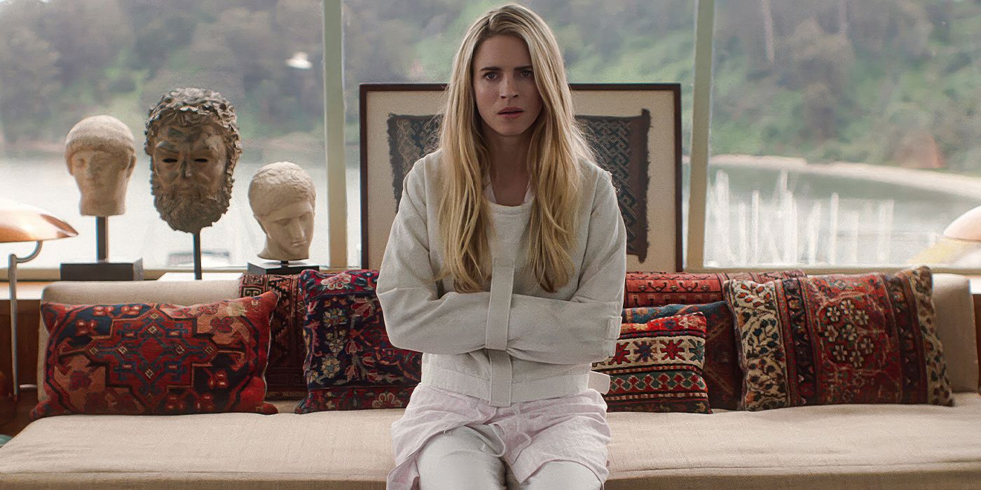 Brit Marling in a straitjacket sits on a couch in a house in The OA.