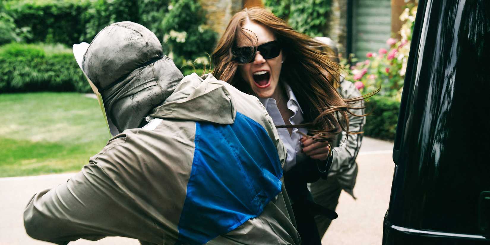 Emma Stone being attacked by a masked figure in Bugonia