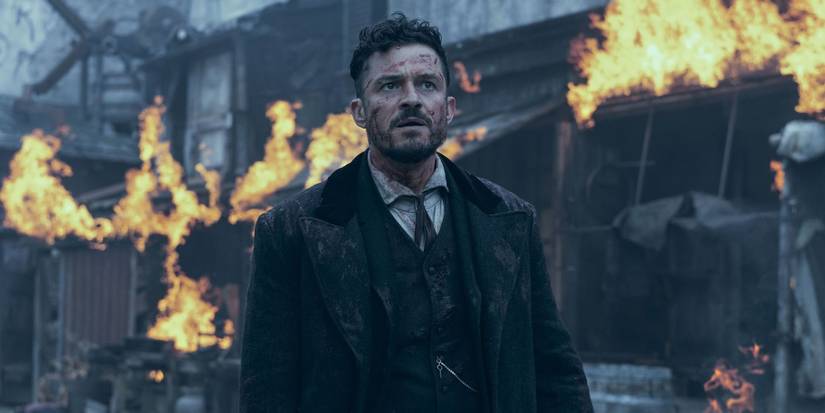 Bloody Philo (Orlando Bloom) walking past buildings on fire in Carnival Row