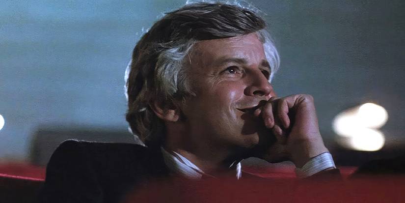 A man smiling while looking at the movie screen in Cinema-Paradiso