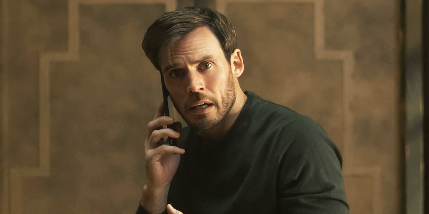 Sam Claflin as Laz holding a cell phone to his right ear while looking concerned in Harlan Coben's Lazarus
