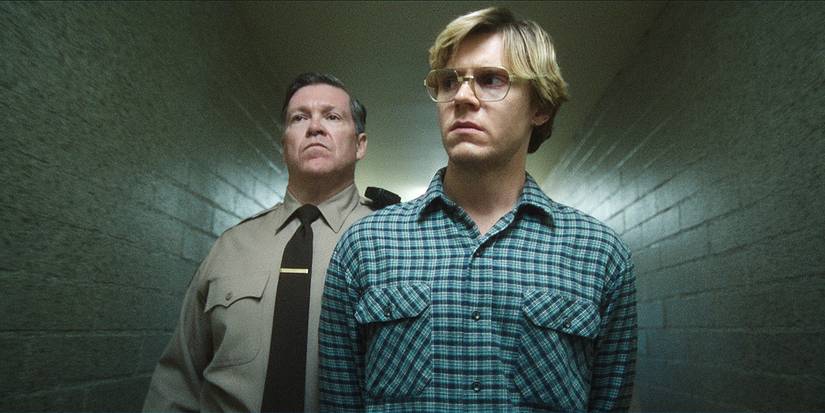 A prison guard is leading Evan Peters in Dahmer-Monster: The Jeffrey Dahmer Story.