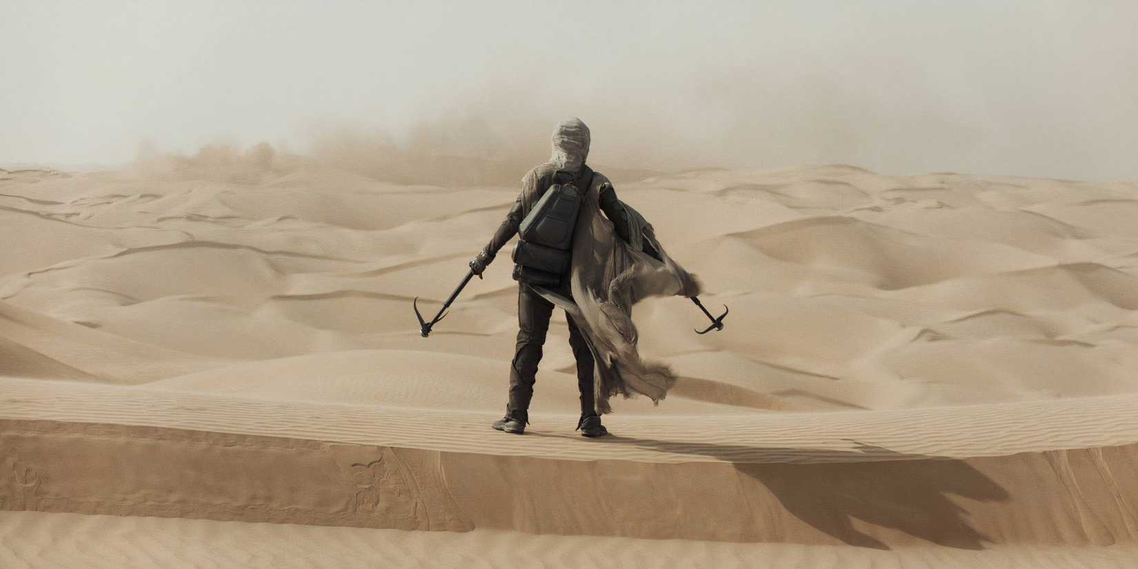A shot of a man standing in the sand in Dune Part One