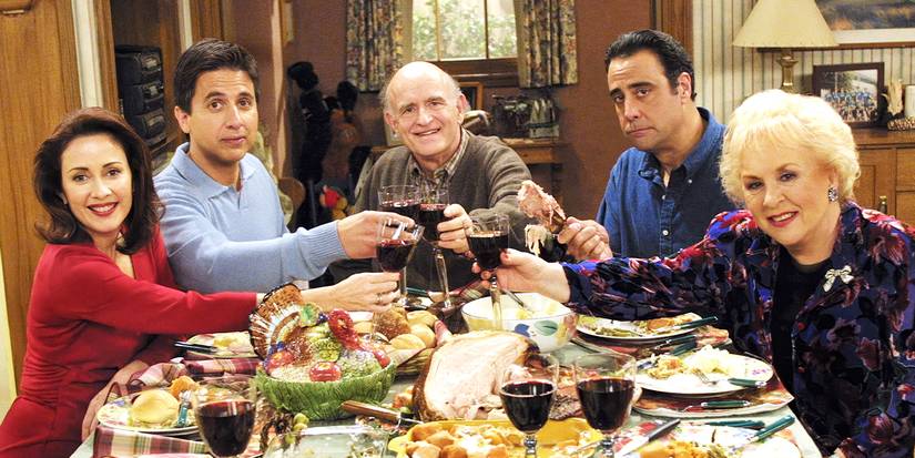 Patricia Heaton, Ray Romano, Peter Boyle, Brad Garrett, and Doris Roberts around a table on the set of Everybody Loves Raymond.