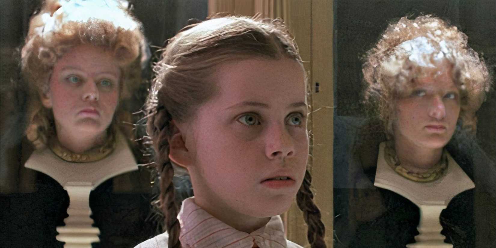 Fairuza Balk in braids with two women as statues behind her in Return to Oz.