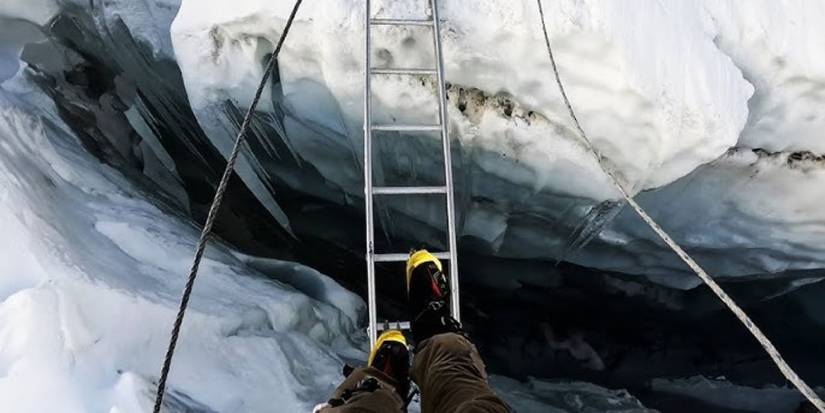A climber looking down at their feet in a still from Farther Than the Eye Can See