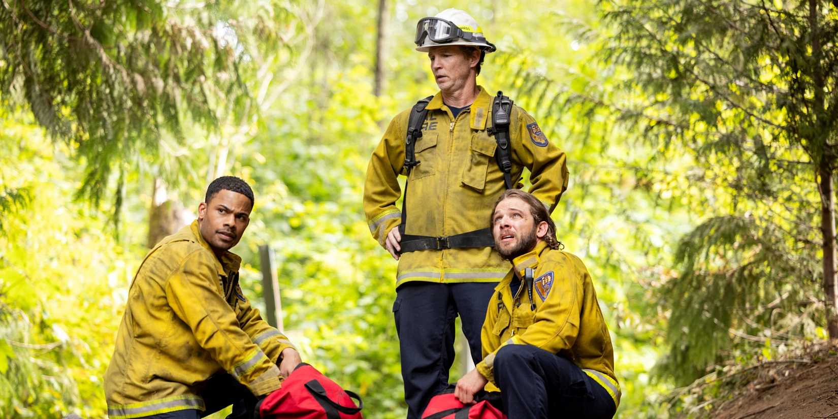 Shawn Hatosy standing over Max Thieriot as Bode and Jordan Calloway as Jake kneeling in Fire Country