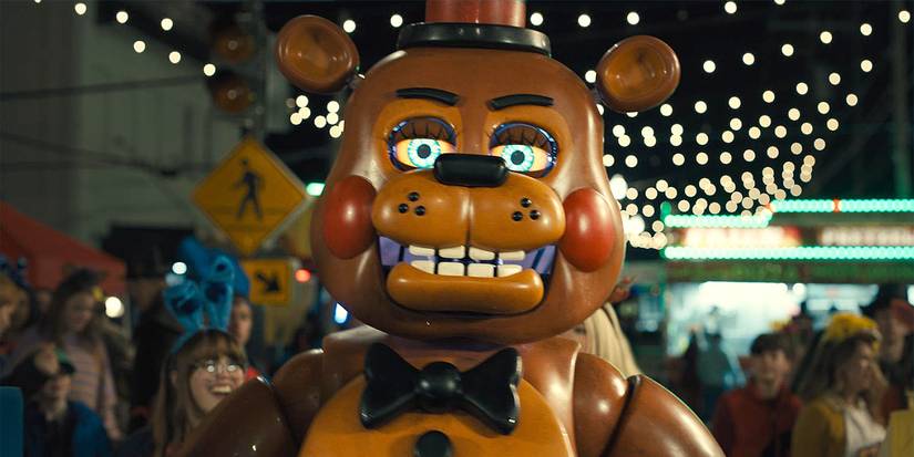 Freddy Fazbear smiling eerily in a crowd at a carnival.