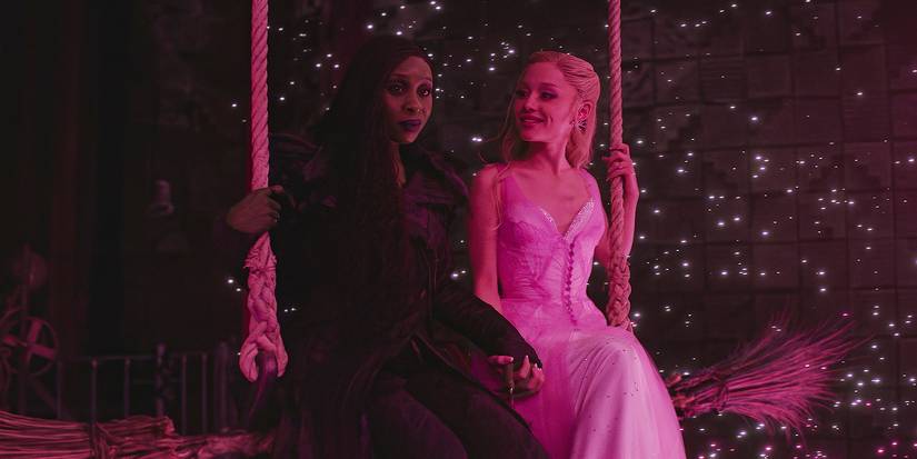Elphaba and Glinda share a swing, surrounded by sparkling lights.