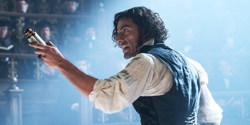 Victor Frankenstein is talking to a room of people, emphatically pointing a gadget at the crowd.